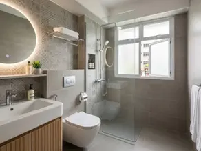 Interior view of a finished HDB toilet renovation by Cosmos Decor renovation contractor, showcasing professional workmanship in tiling and fixture installation, with a clear view of an HDB estate outside the window.