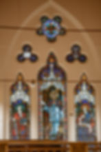 Colourful stained-glass windows set within a tall pointed church arch