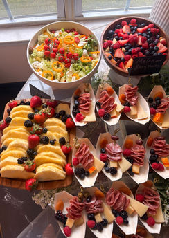 Full overhead grazing table with salad bowl, berry medley, pineapple board, and charcuterie cones for NJ catering