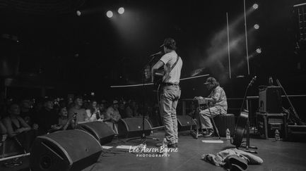 Black and white photo of musicians performing on stage.