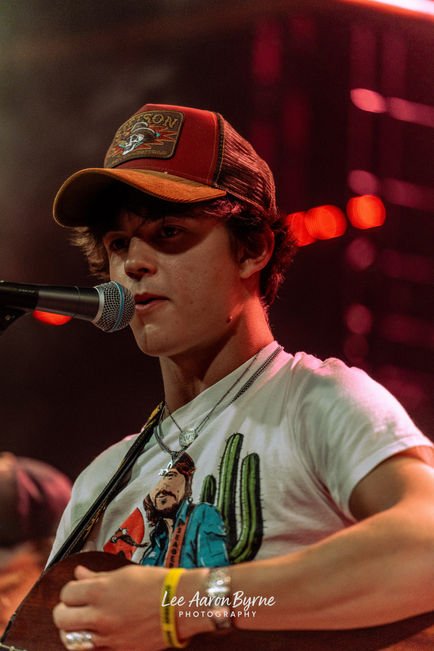 Young musician performing on stage with microphone.