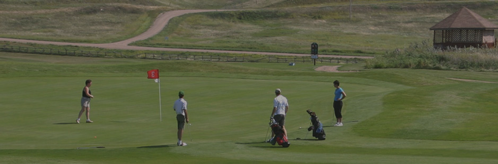 Golf hole with people on the green putting