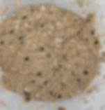 Combined wet and dry ingredients making a high protein banana oat muffin batter. in a white bowl