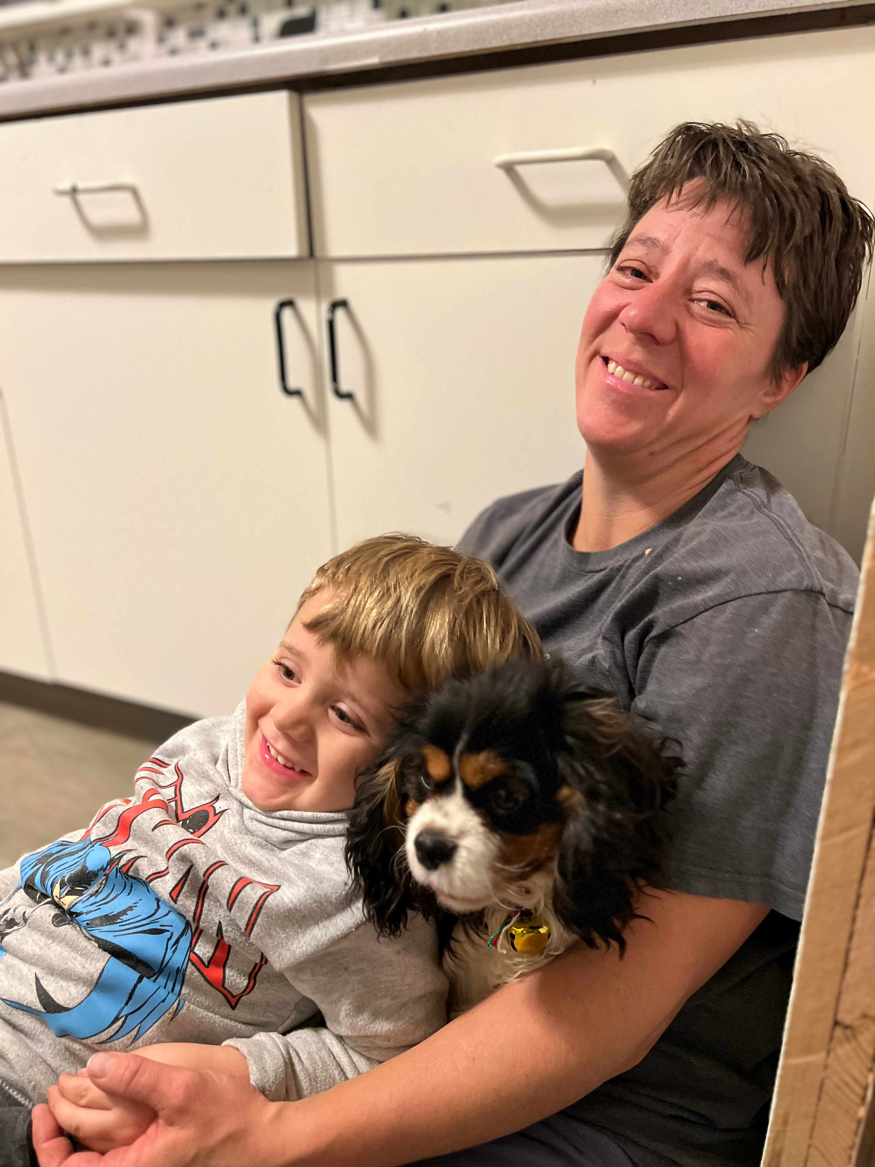 A Cavalier therapy dog sitting calmly in a lap, providing the physical contact necessary to trigger oxytocin release and lower cortisol.