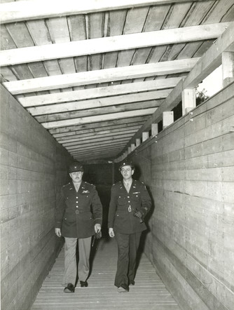 Colonel Burton Andrus, prison commandant and head of the Internal Security Detachment (ISD), walks through a constructed corridor between the jail and courthouse