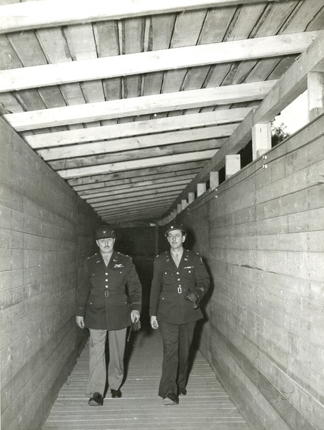 Colonel Burton Andrus, prison commandant and head of the Internal Security Detachment (ISD), walks through a constructed corridor between the jail and courthouse