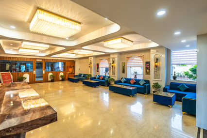 Architectural photograph of an elegant hotel lobby with blue sofas and decorative lighting.
