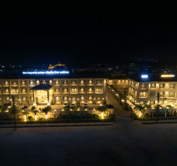Architectural photograph of the Imperial Prime Hotel at night with glowing lights setting.