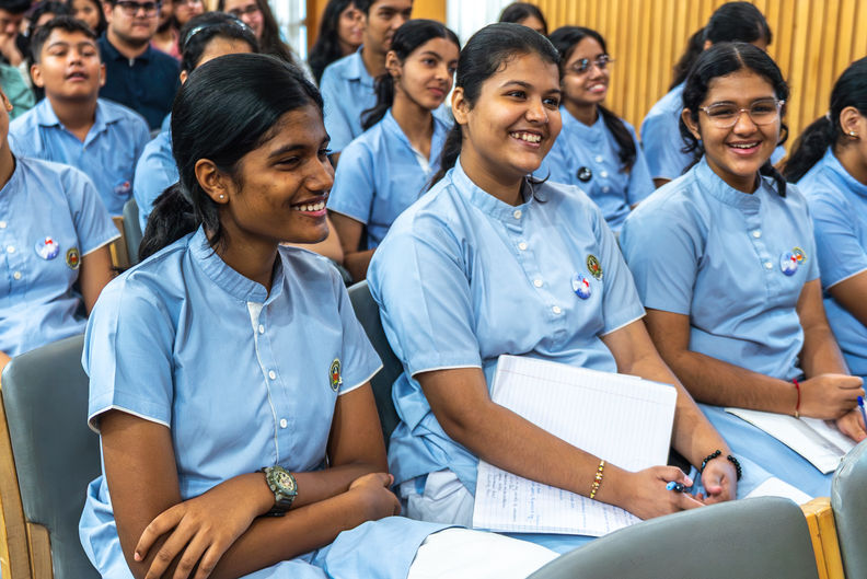 Smiling students in blue uniforms attend a lecture or class EVENTS at school.