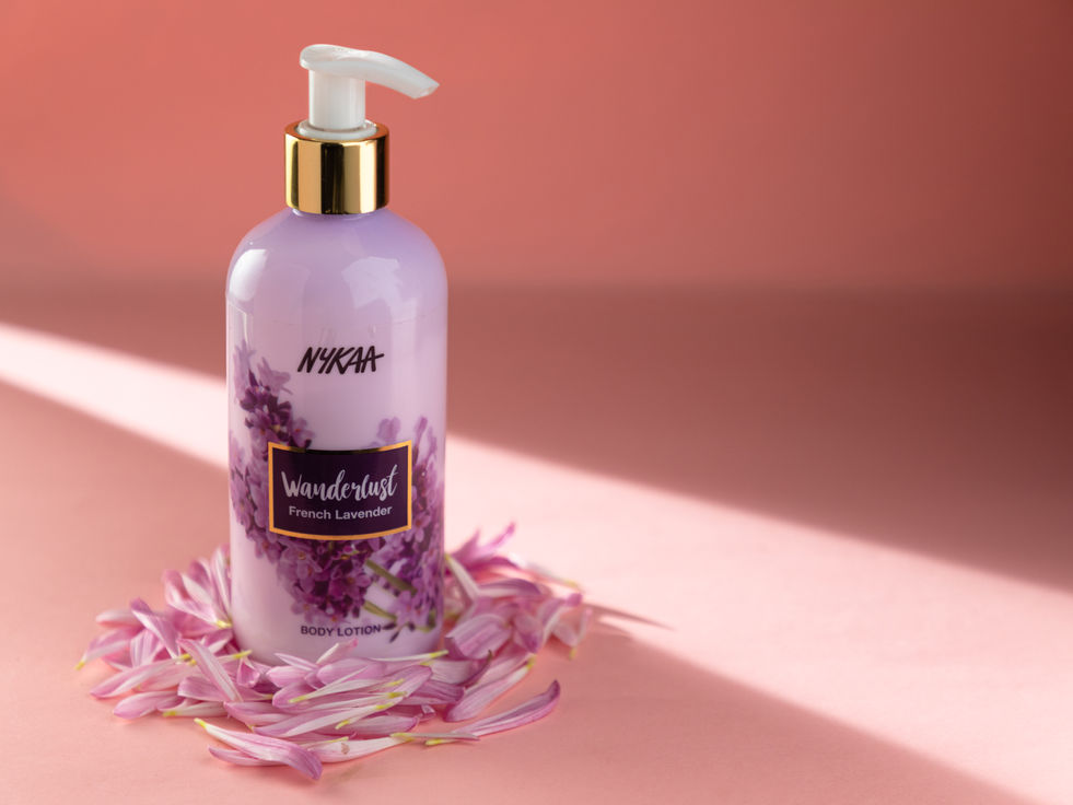 Nykaa Wanderlust French Lavender lotion PRODUCT on pink background with flower petals.
