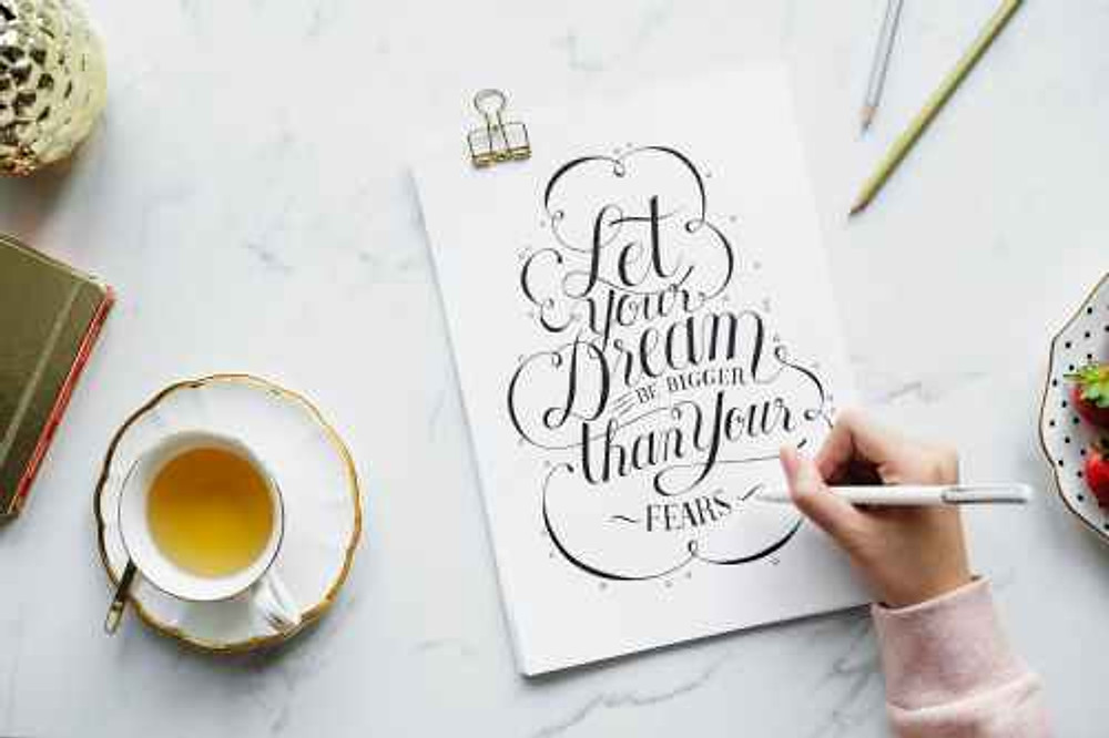 person holding white pen near white poster