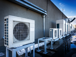 Heating and Air Conditioning units lined up on a commercial building roof.