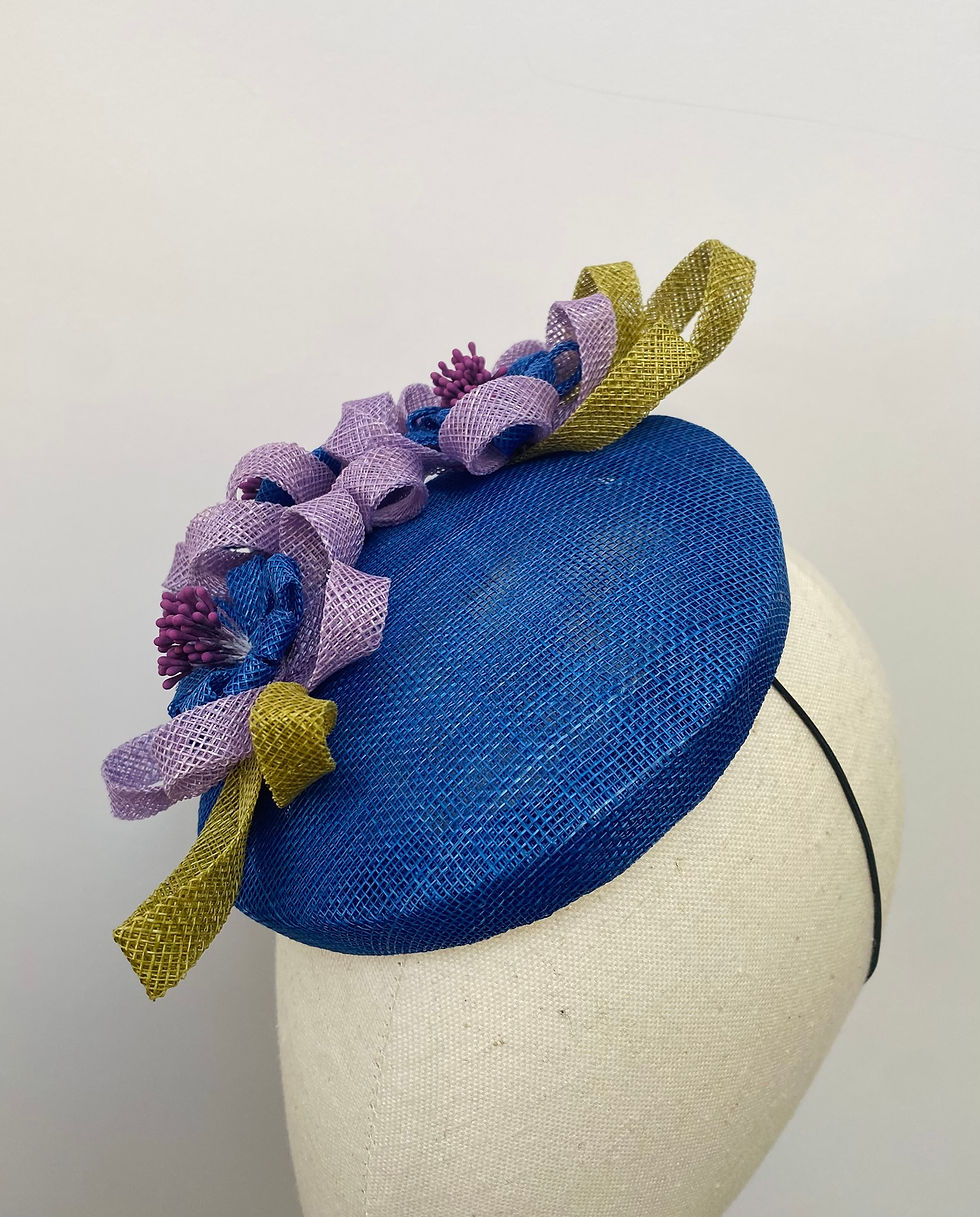 Thumbnail: Bright blue wedding hat with looped flowers and leaves displayed on a mannequin head