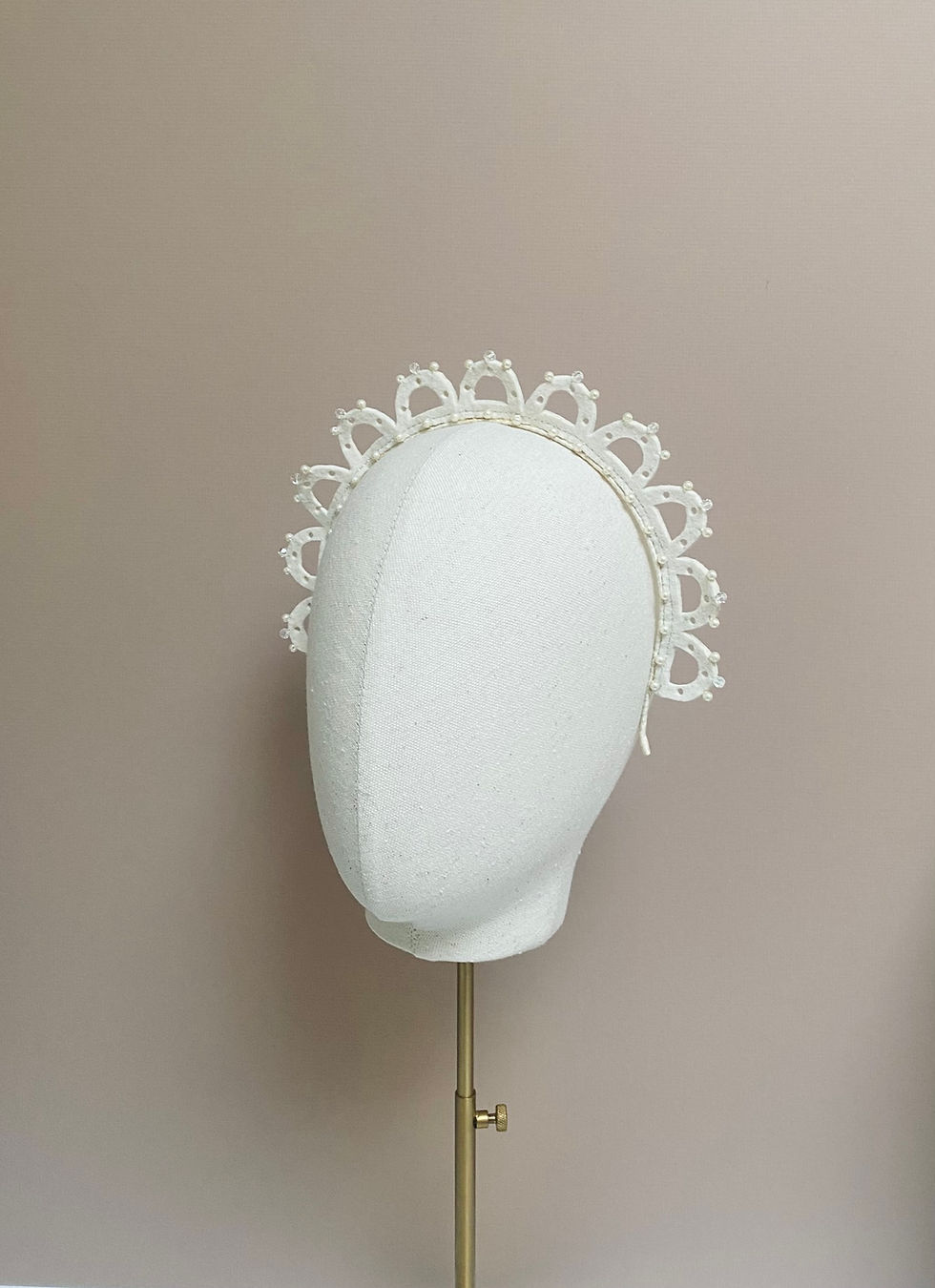 Thumbnail: Front view of an ivory wedding crown displayed on a mannequin head