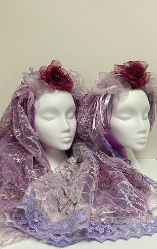Two purple lace wedding veils displayed on mannequin heads
