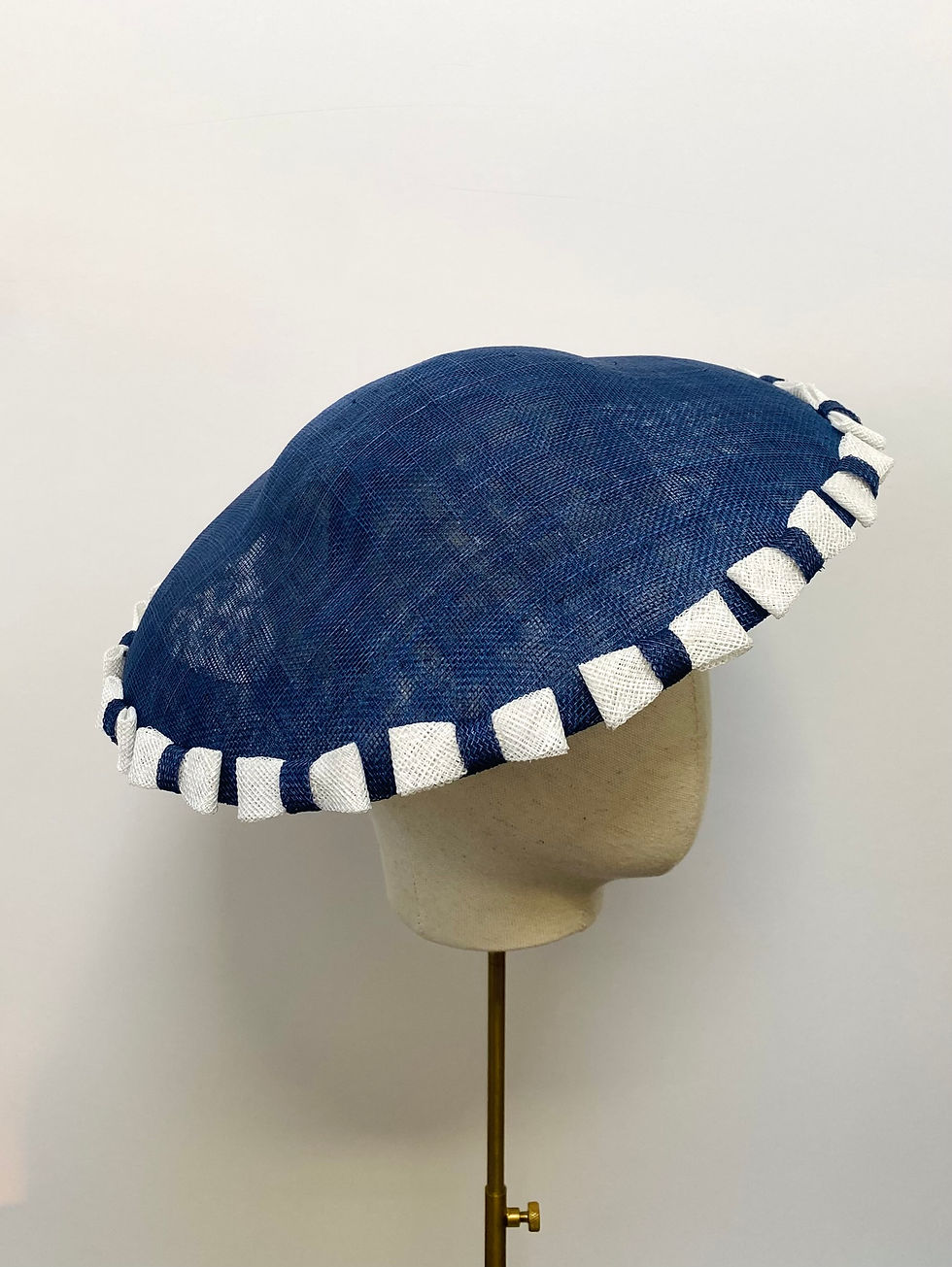 Thumbnail: A blue and white saucer hat with bows is displayed on a mannequin head