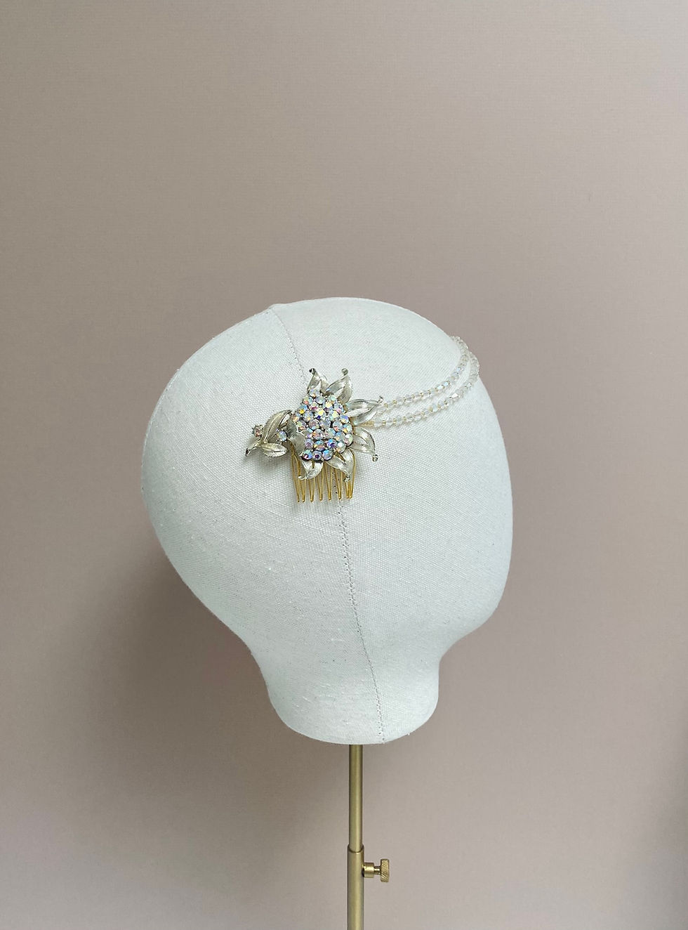 Thumbnail: A crystal beaded bridal headband with a vintage brooch detail is displayed on a mannequin head