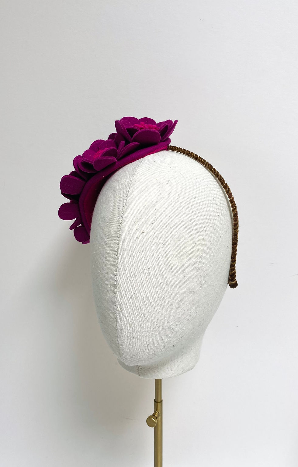 Thumbnail: A hot pink felt floral headpiece is displayed on a mannequin head