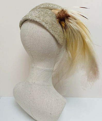 Back view of a beaded headpiece with cream feather displayed on a mannequin head
