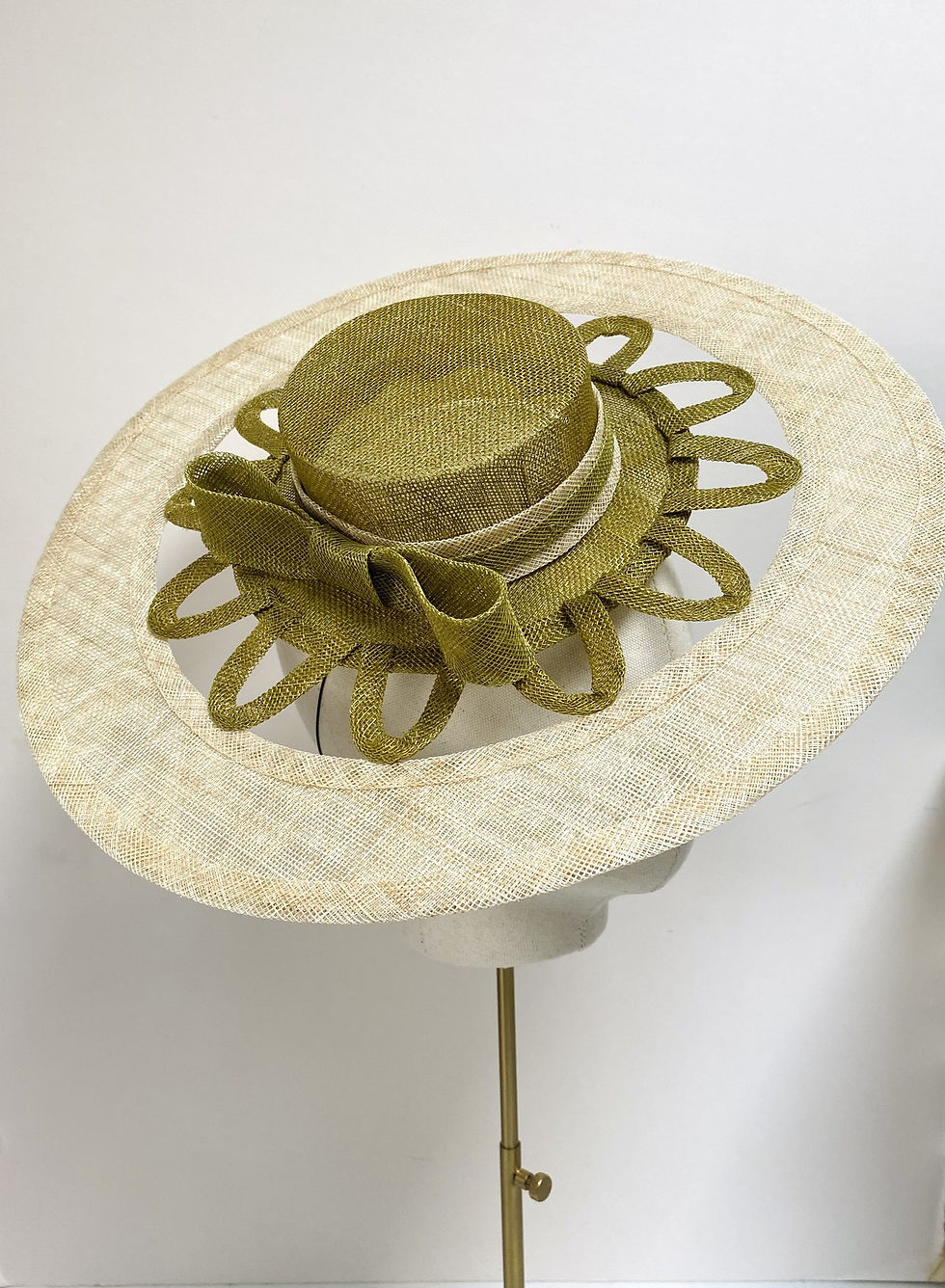 Thumbnail: A two tone women's boater hat with cut out detail is displayed on a mannequin head