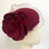 Thumbnail: A dark red felt flower wedding hat with a veil is displayed on a mannequin head
