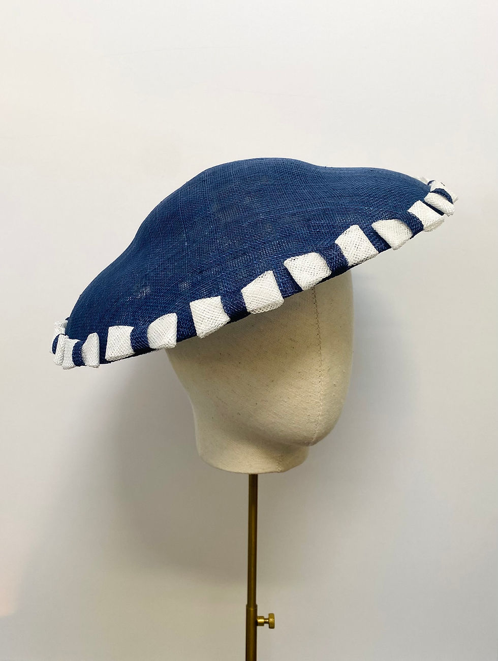 Thumbnail: A blue and white saucer hat with bows is displayed on a mannequin head