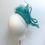 Thumbnail: An aqua green wedding hat with a matching bow and spot veiling is displayed on a mannequin head
