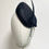 Thumbnail: A black fascinator hat with feathers is displayed on a mannequin head