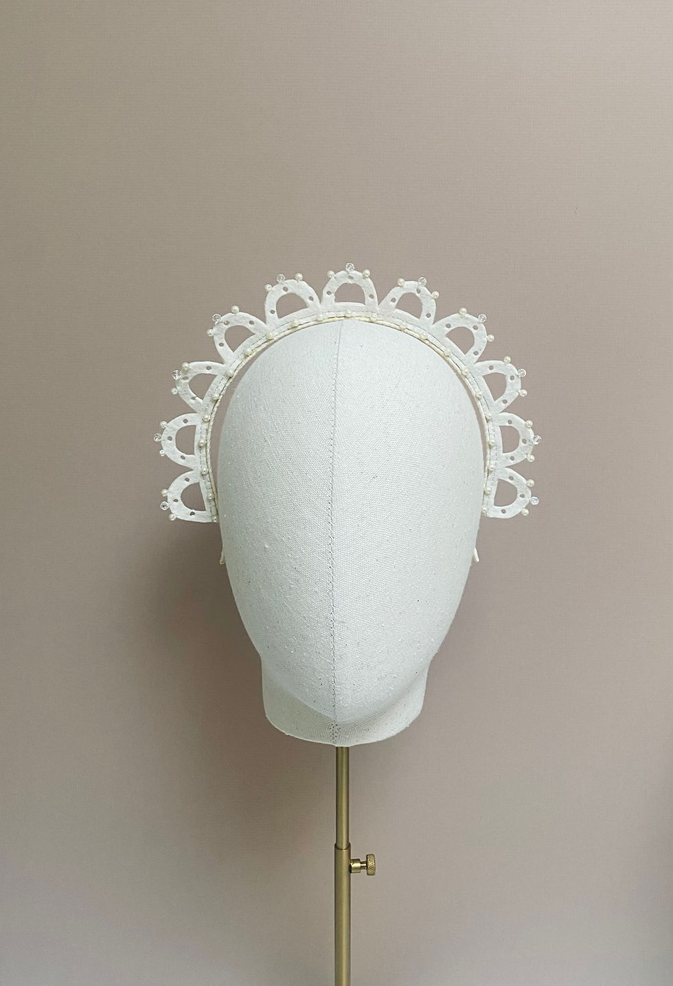 Thumbnail: Front view of an ivory wedding crown displayed on a mannequin head