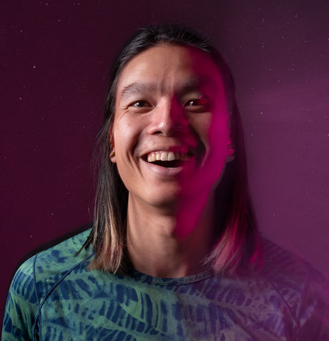 Creative headshot of an athlete under pink lighting, captured in-studio with motion blur for a bold, modern portrait style.
