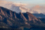 Telephoto view of the Flatirons near Boulder, Colorado with layered mountain ridges and distant snowcapped Longs Peak and Mou
