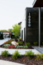 Multi-colored flower bed with boulder alongside apartment building