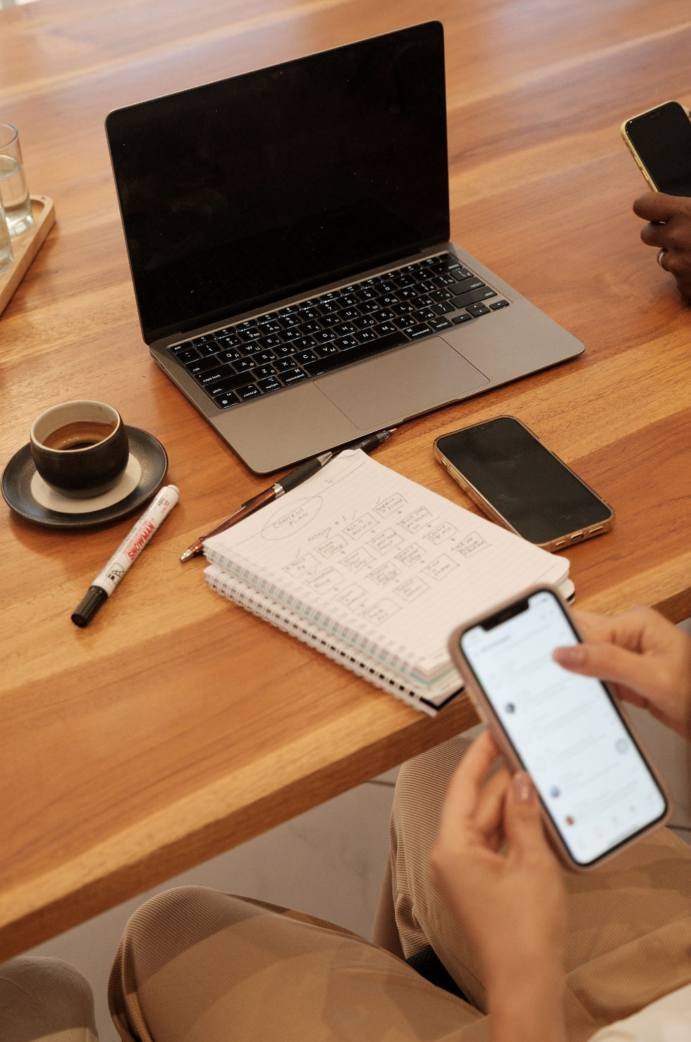 Laptop and notebook sitting on wooden table