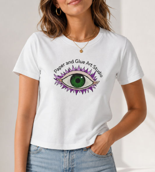 Image of a green eye with purple lashes with the name of the art studio arched above the eye