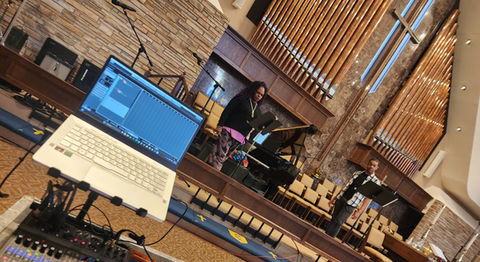 Singers and pianist on stage while engineer records.