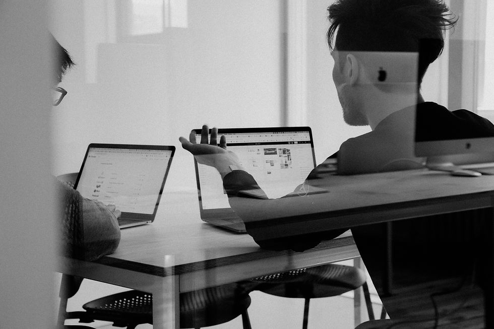 Zwei Personen arbeiten an Laptops zusammen