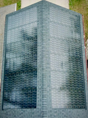 Arial shot of a roof with dark grey shingles as well as integrated black solar shingles