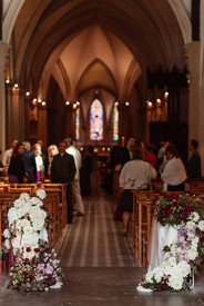 Ceremony aisle decorated with elegant white and red floral arrangements