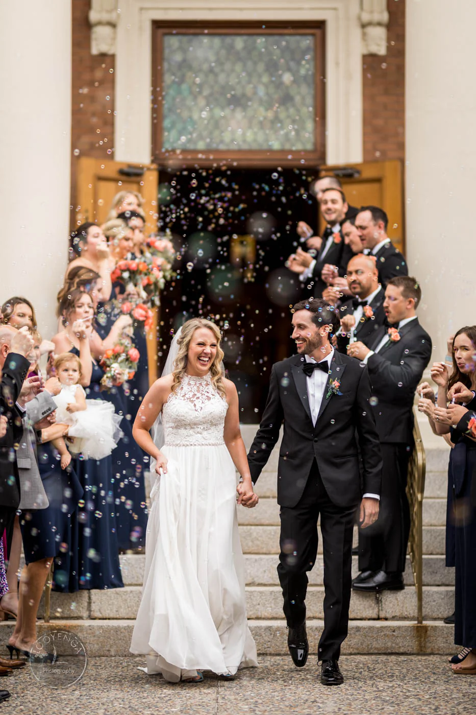 bride and groom walking through guests