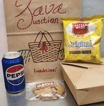 A "boxed lunch" including a sandwich, chips, soda, and a cookie.