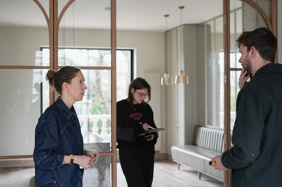 Leo Wood discussing design details with a client during a residential renovation, reviewing the interior scheme and final design decisions on site.