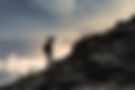 Man getting ready to climb up mountain looking up at the challenge before him planning pat