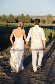 Bride and groom walking away in the sunset.