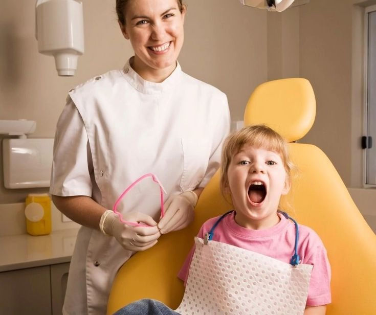 Child smiling during a dental visit at a pediatric dental office in Darien while receiving positive reinforcement and supportive care