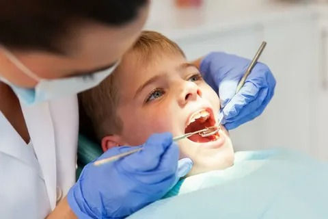 Pediatric dentist in Darien applying dental sealants to a child’s molars.
