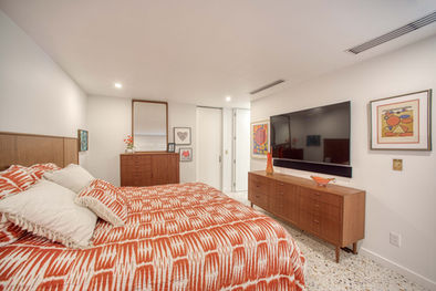 Mid-century modern bedroom with custom wood cabinetry and built-in television