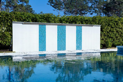 Custom pool feature wall with blue and white vertical tile accents