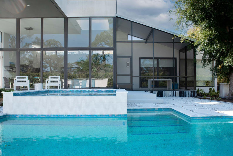 Custom pool and raised spa with blue tile and white finishes