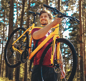 positive-sporty-male-holding-yellow-mountain-bicycle-upper-his-head.jpg