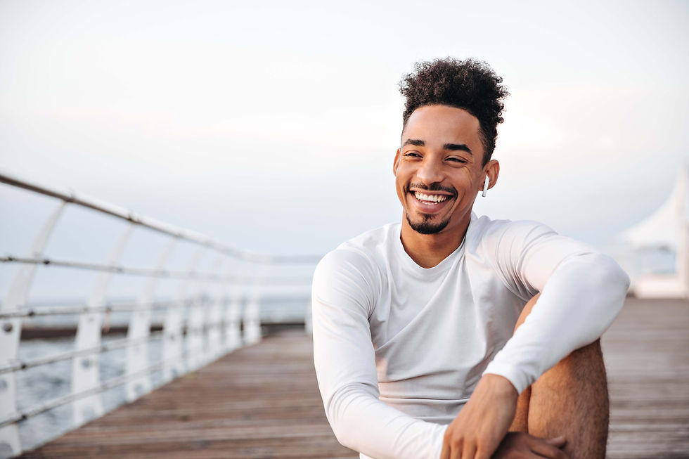 COMPRESSEDcheerful-curly-dark-skinned-man-white-long-sleeved-t-shirt-smiles-sincerely-rest
